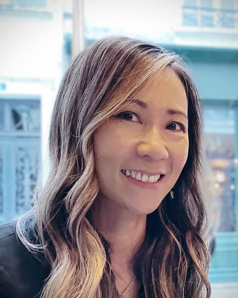 Dr. Trang Eng, smiling, with long wavy hair